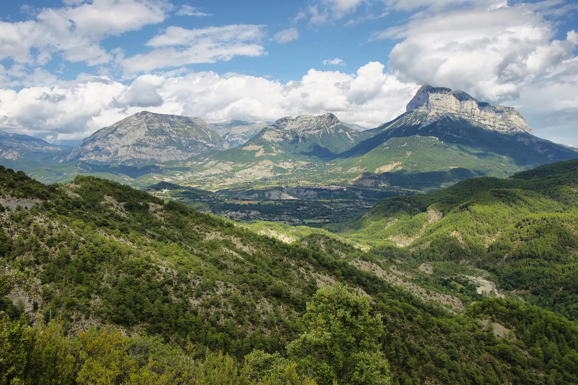 A green mountain valley with peaks above