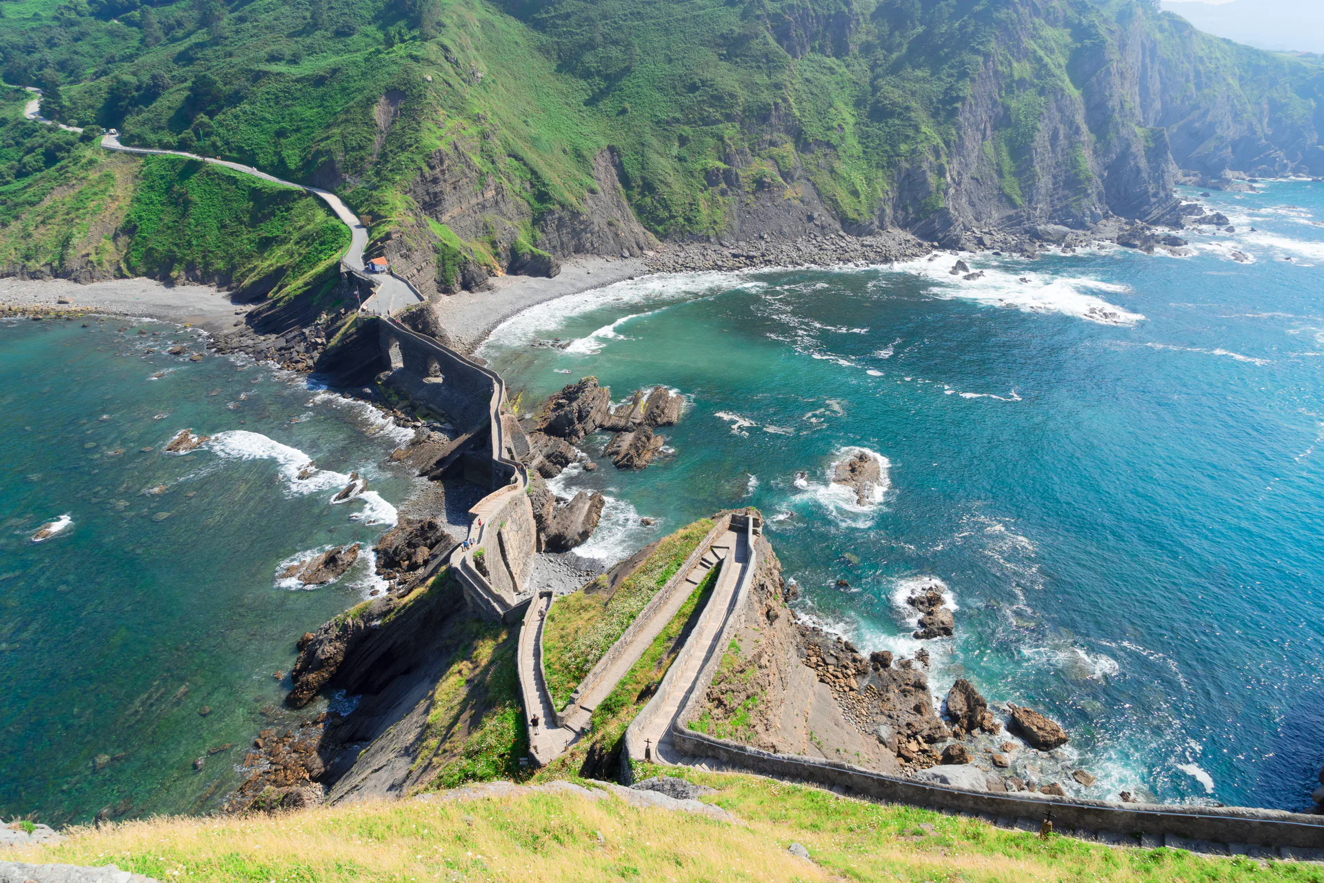 A stone walkway along a green Atlantic headland