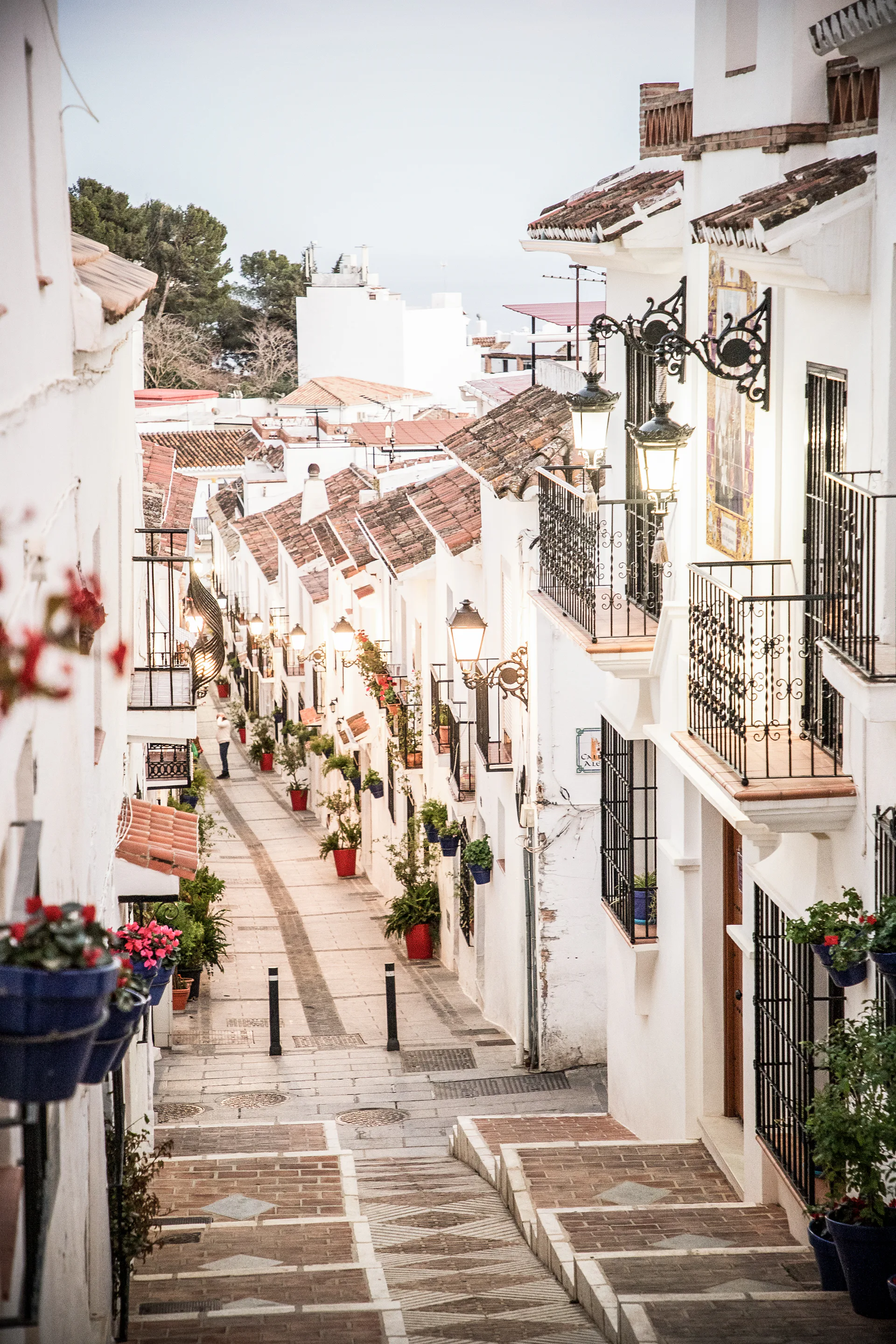A stepped street in a white village, with balconies and tiled roofs.